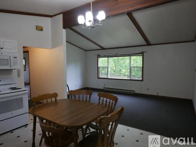 A dining room with a wooden table and chairs.