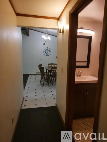 A bathroom with a mirror, sink, and a dining table with chairs.