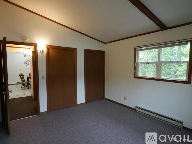 A room with a window, a clock, and two doors.