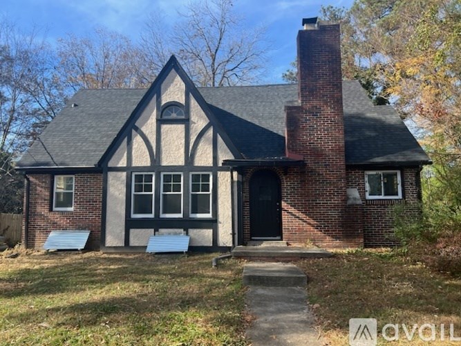 A house with a black door and a brick chimney.