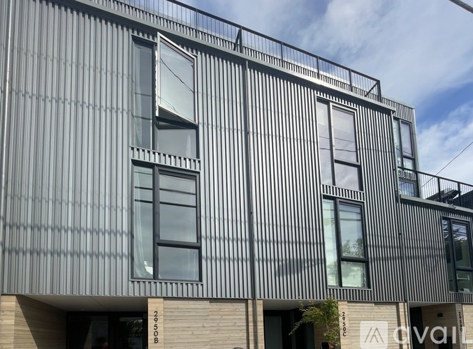 A modern building with a corrugated metal facade and large windows.
