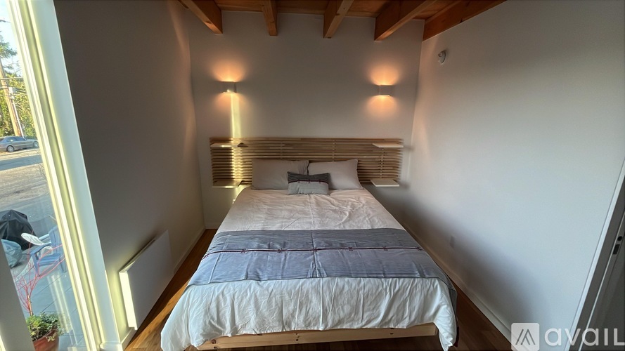 A bedroom with a large bed and a window overlooking a parking lot.