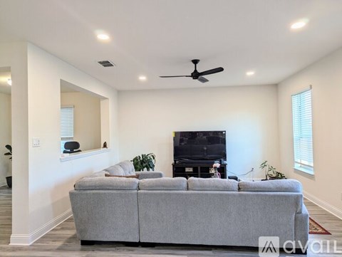 A living room with a grey couch and a television.