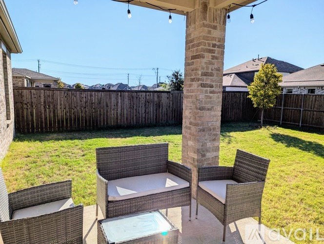 A patio with a table and chairs and a hot tub.
