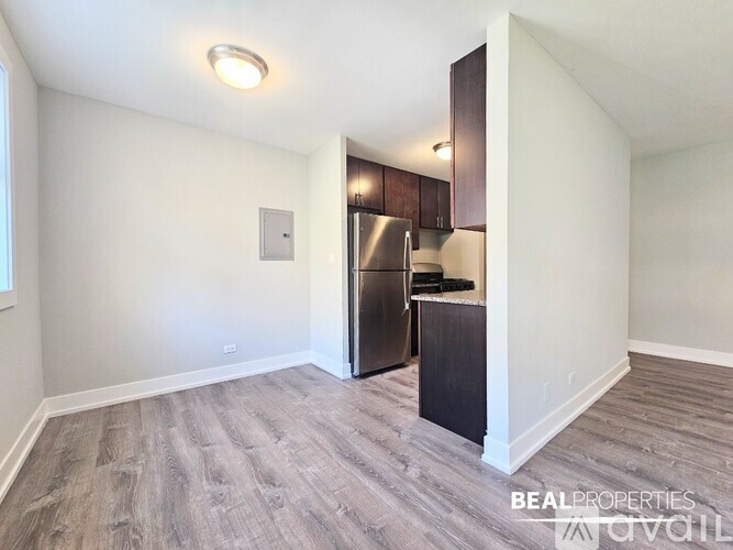 A spacious room with wood flooring and a built-in cabinet.