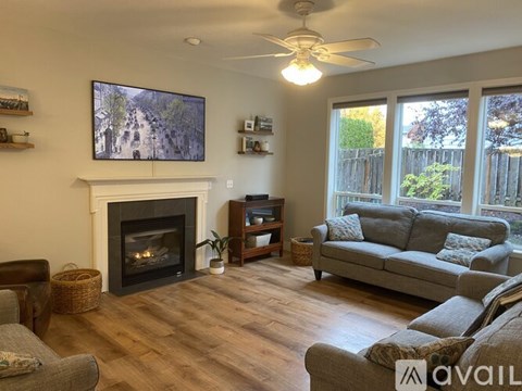 A living room with a fireplace and a television mounted above it.