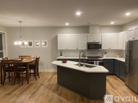 A kitchen with a center island and a dining table.