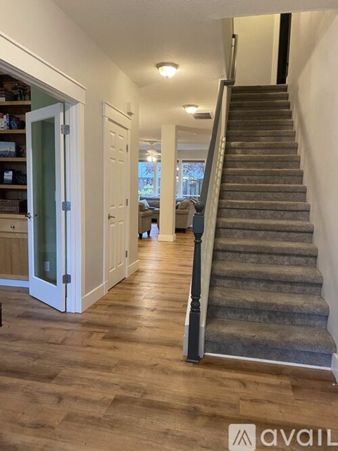 A staircase with a carpeted runner leads up to a landing with a door.