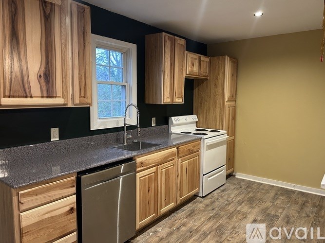 A kitchen with wooden cabinets and a stainless steel dishwasher.