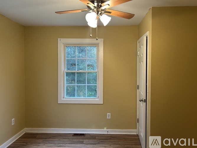 A room with a ceiling fan and a window.