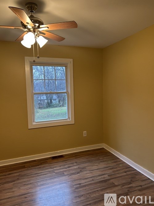 A room with a ceiling fan and a window.
