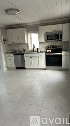 A kitchen with white cabinets and appliances.