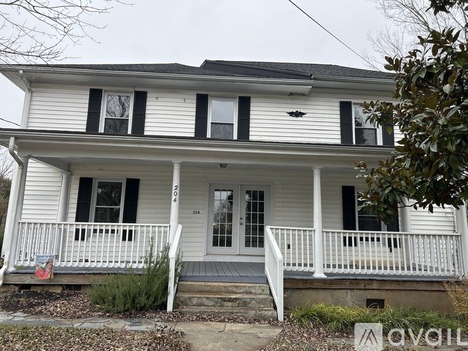 A white house with black shutters and a porch.