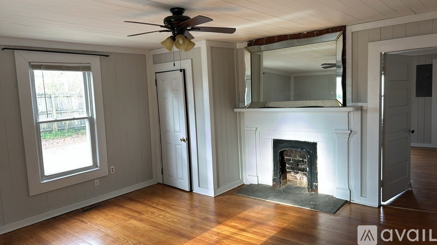 A room with a fireplace and a ceiling fan.