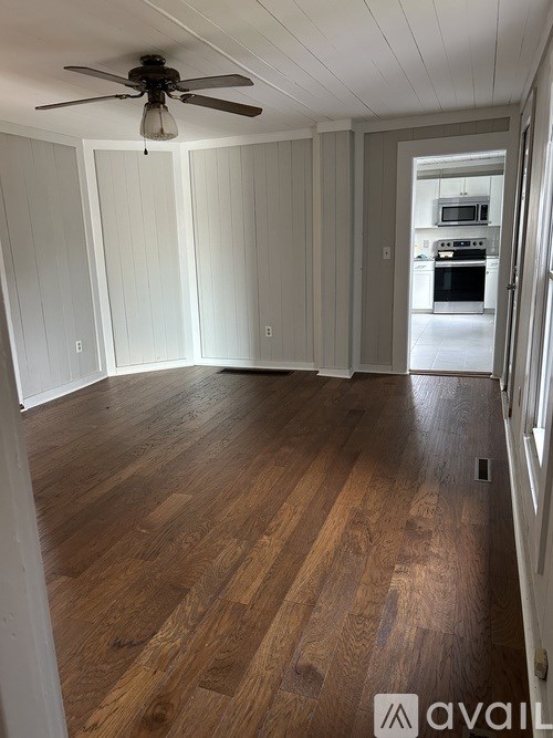 A room with wooden floors and a ceiling fan.
