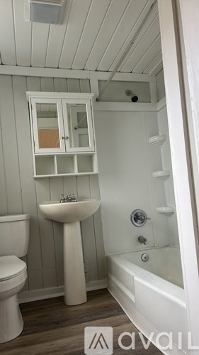 A white bathroom with a toilet, sink, and bathtub.