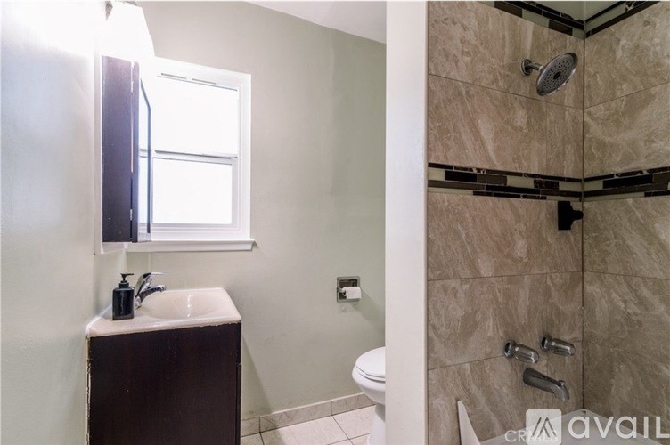 A bathroom with a toilet, sink, and shower.