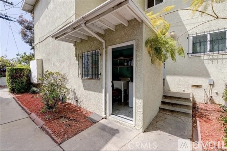 A house with a red mulch bed in front of it.