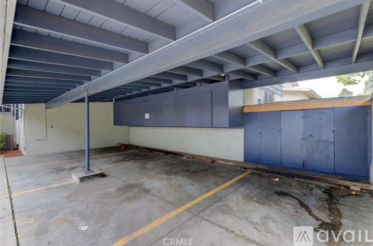 A large, empty parking garage with a concrete floor and a metal roof.