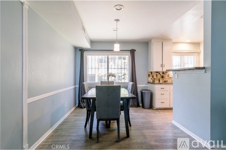 A dining room with a table and chairs.