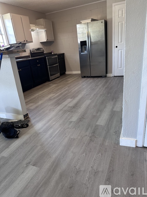 A kitchen with a refrigerator, oven, and cabinets.
