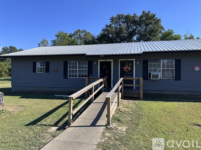 A grey house with a metal roof and a porch.