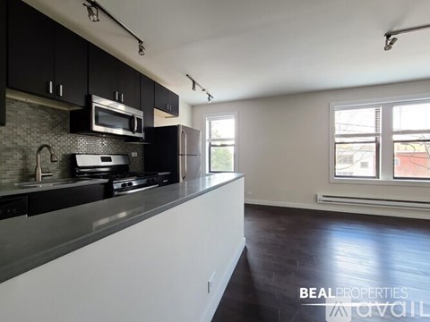 A kitchen with black cabinets and a white countertop.