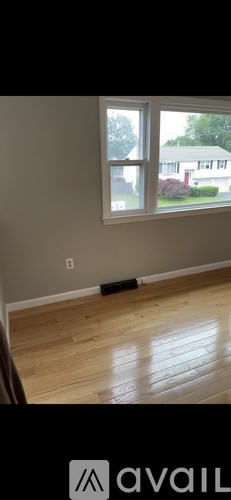 A room with a window and wooden flooring.
