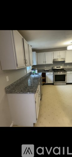 A kitchen with white cabinets and a granite countertop.