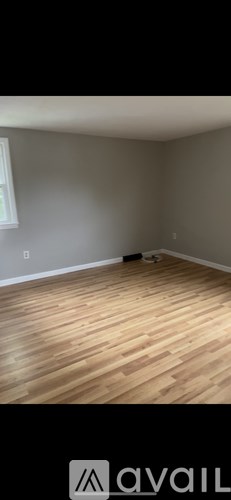 A room with wooden flooring and a window.