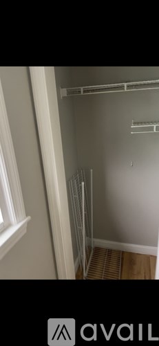 A white closet with a shelf and a window.