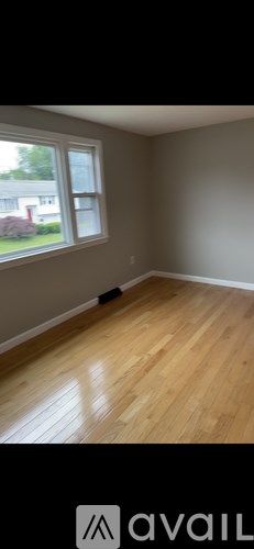 A room with wooden flooring and a window.
