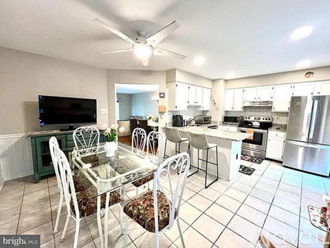 A kitchen with a dining table and chairs.