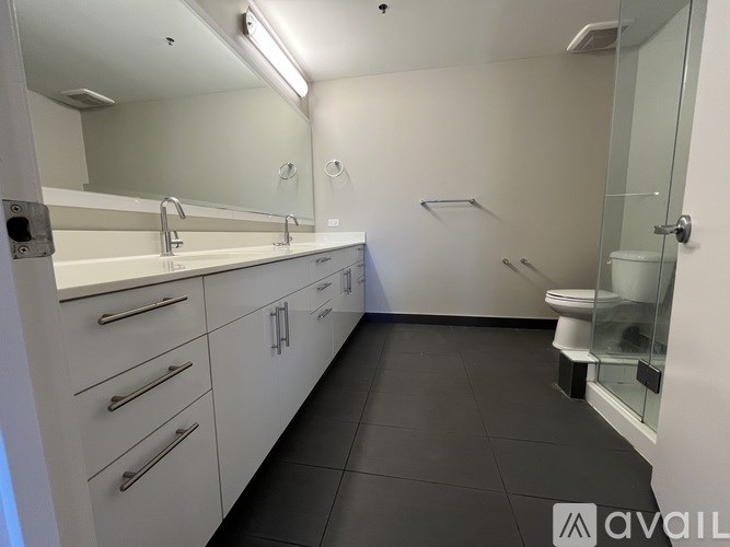 A bedroom with a bed, desk, and a window with blinds.