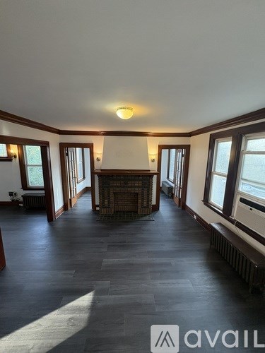 A spacious living room with a fireplace and large windows.