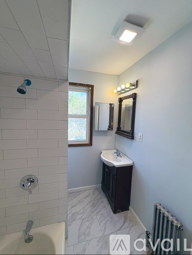 A bathroom with a white sink and a window.