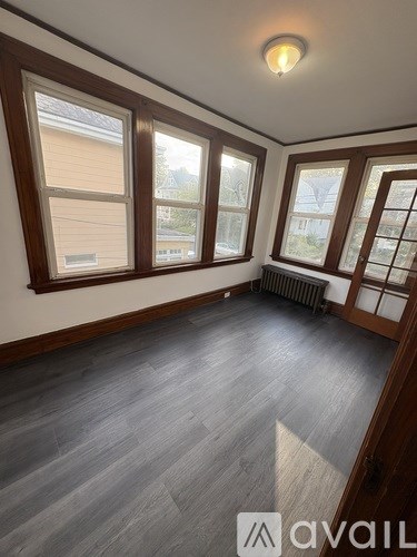 A room with wooden floors and a window with blinds.