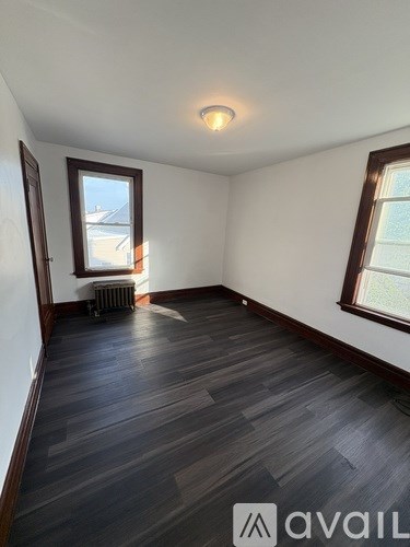 A room with wooden flooring and a window.