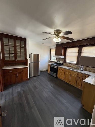 A kitchen with wooden cabinets and a refrigerator.