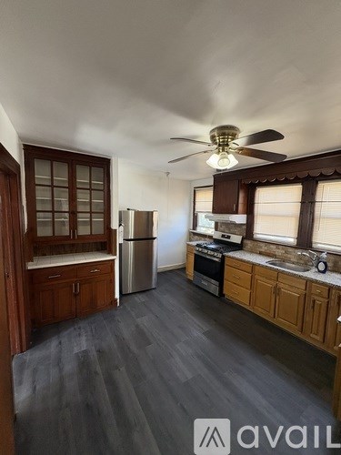 A kitchen with wooden cabinets and a refrigerator.