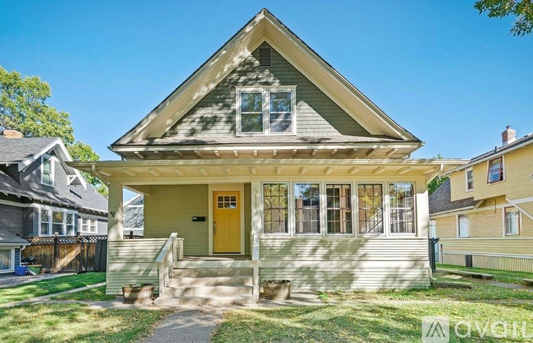 A house with a yellow door is surrounded by other houses.
