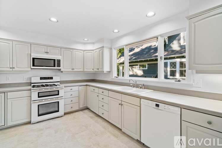 A kitchen with white appliances and cabinets.
