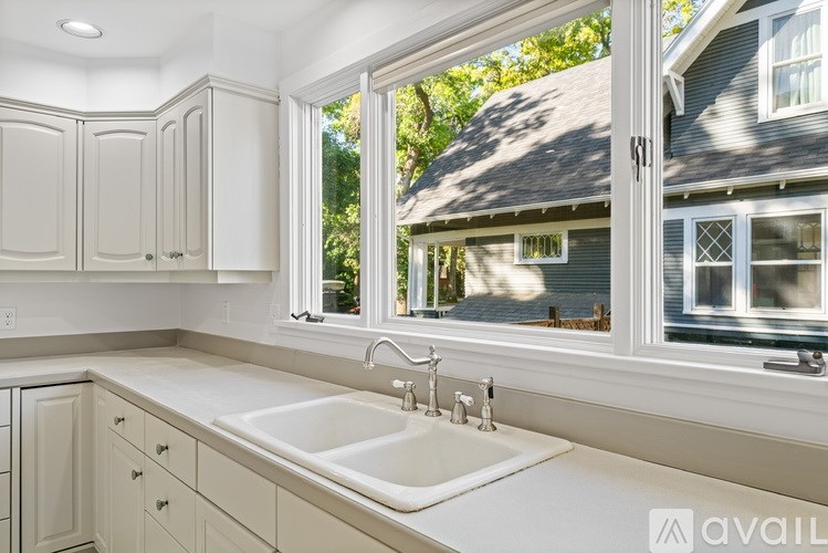 A kitchen with white cabinets and a white sink.