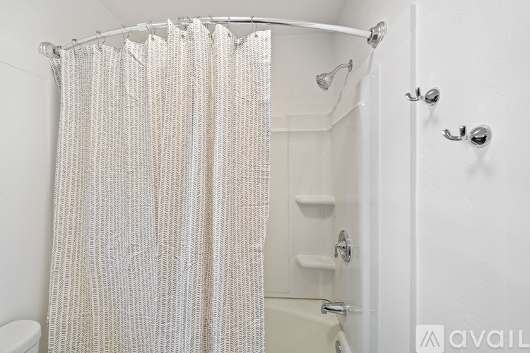 A white shower curtain in a bathroom.