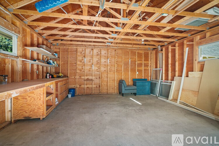 A room under construction with exposed wooden beams and unfinished walls.