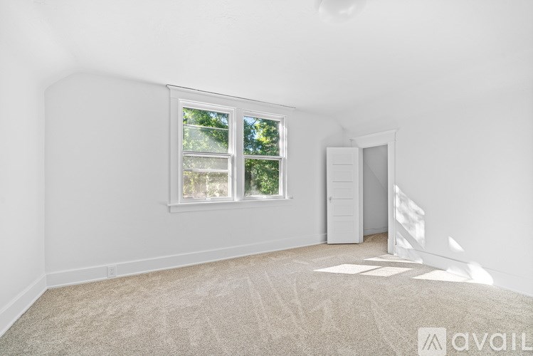 A room with a window and a door is available for rent.