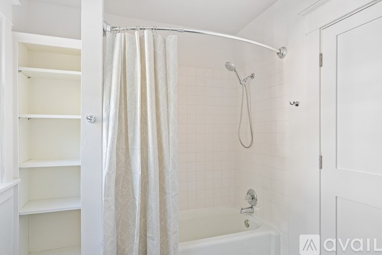 A white bathroom with a shower curtain and a tub.