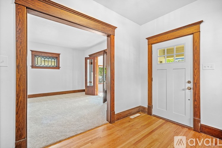 A room with a white door and a window with a wooden frame.