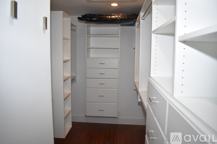 A white walk-in closet with shelves and drawers.