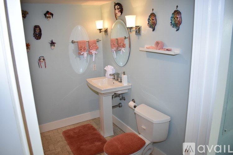 A bathroom with a sink, toilet, and a mirror.